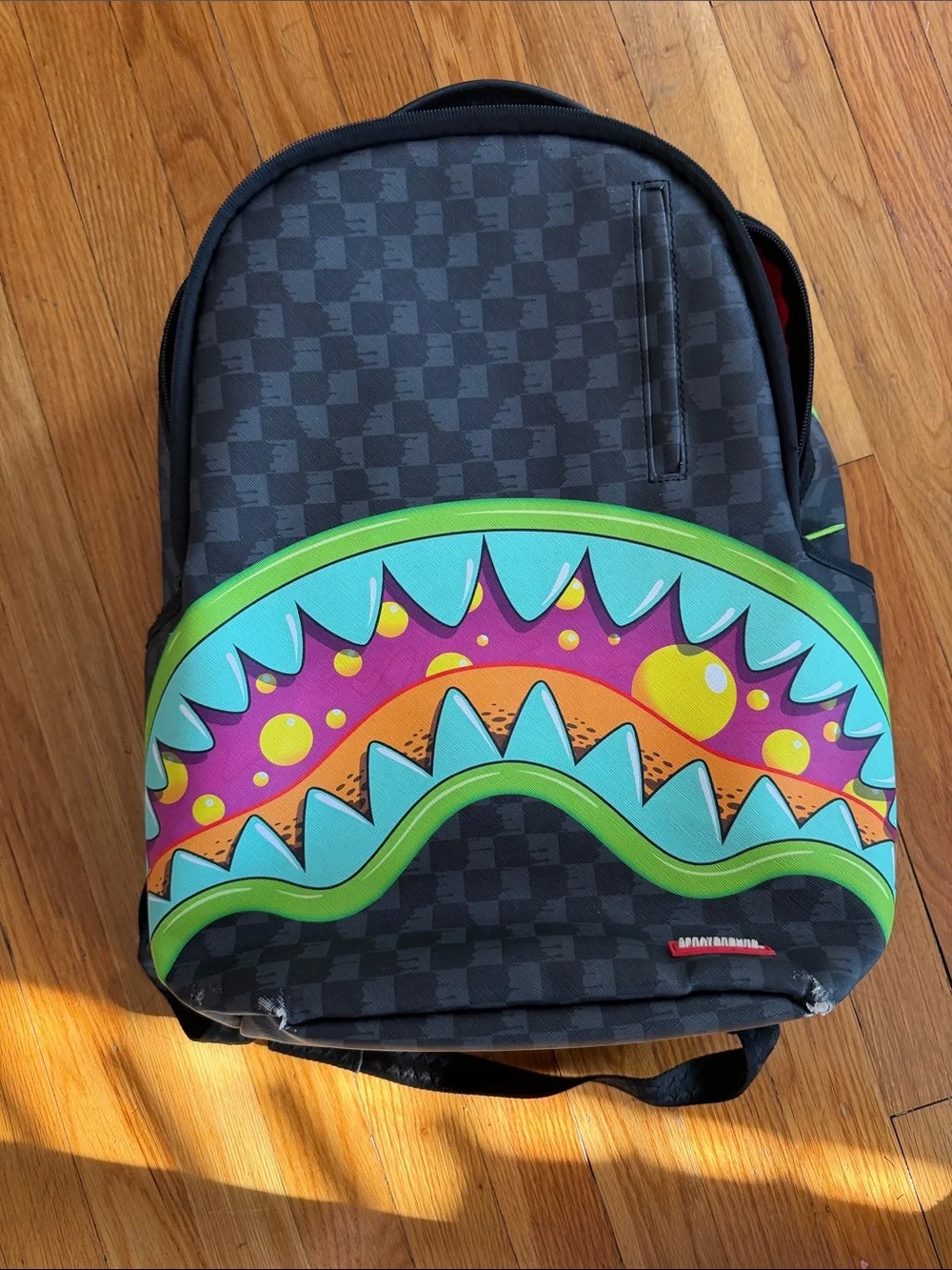 Sprayground Black Checkerboard Kids Backpack with Neon Shark-Mouth Graphic
